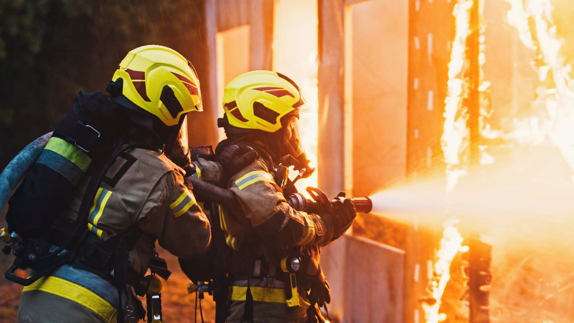 Feuerwehrleute in Schutzkleidung löschen einen Brand